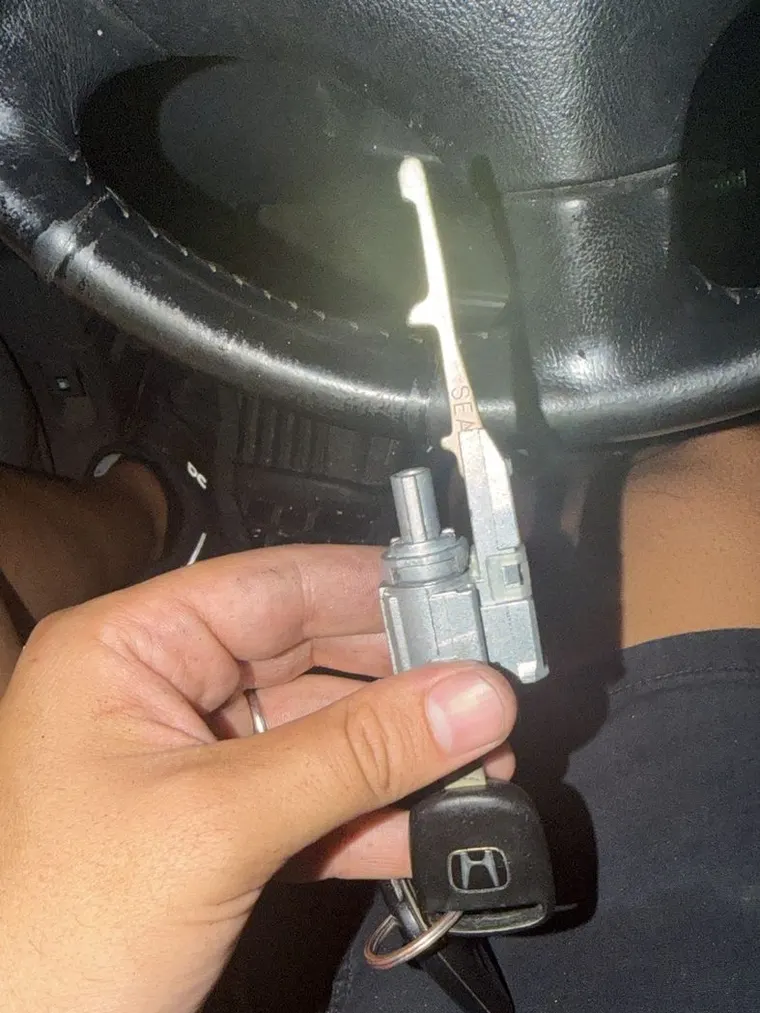 A cut Honda key held next to the car door lock cylinder it matches