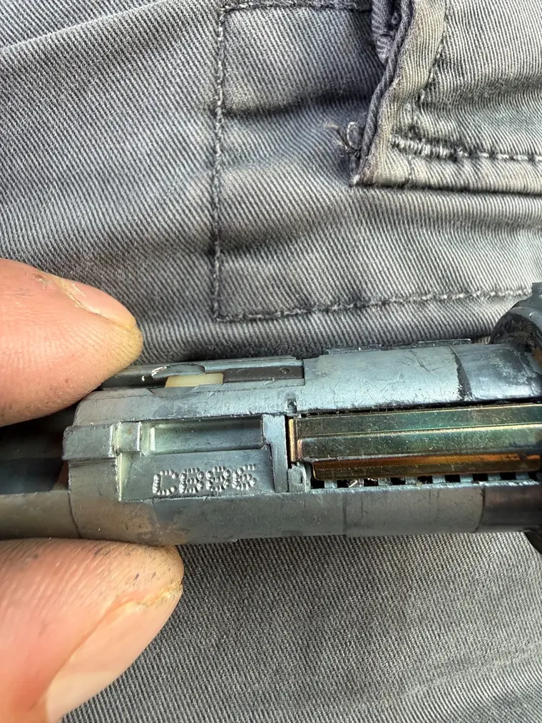 A car door lock cylinder removed and held for decoding