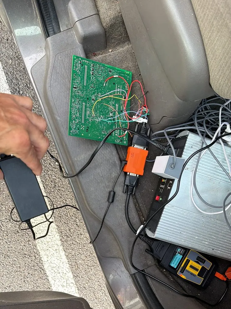 Key programming equipment laid out in a car footwell