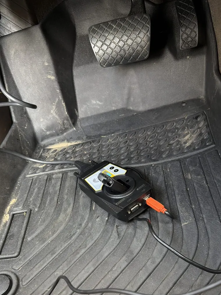 A key programming tool on the floor mat beside the pedals