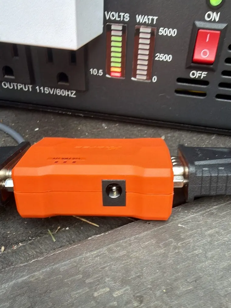 A programming adapter and power inverter set up on a bench