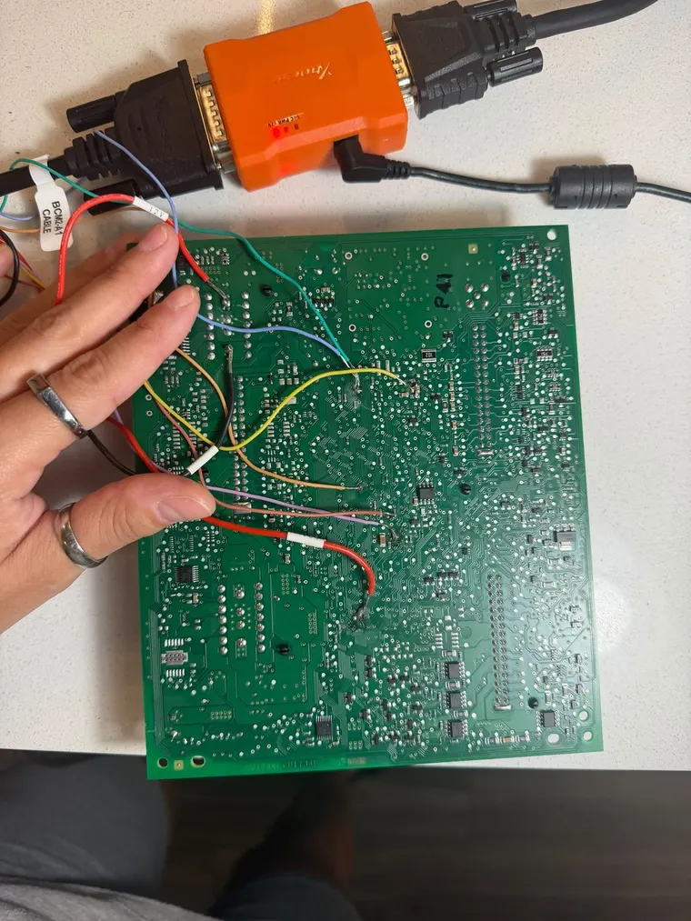 A wired module board held while its data is read