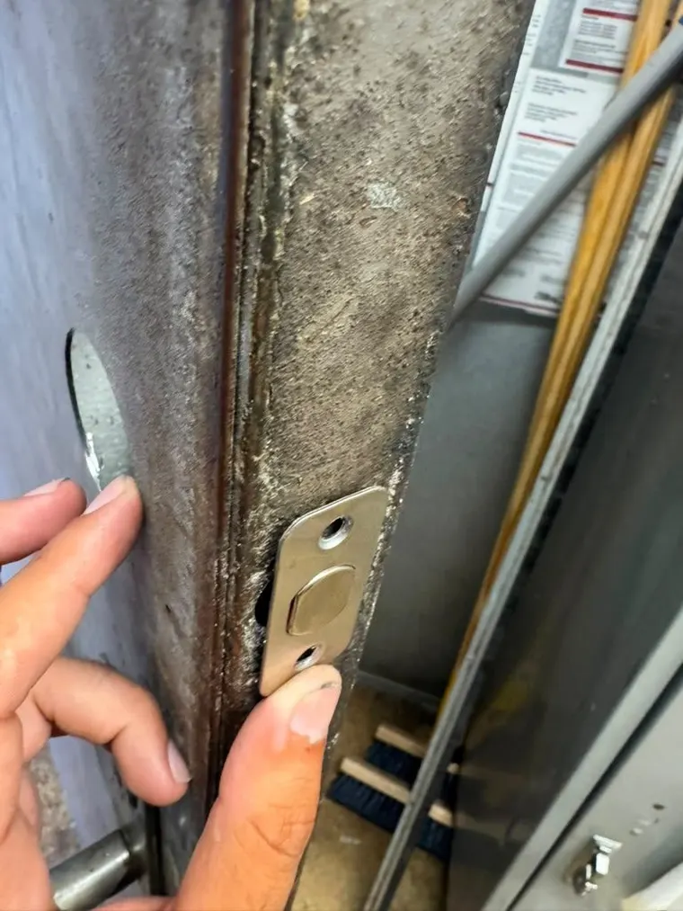 A rebuilt strike plate on a commercial door frame after a forced entry