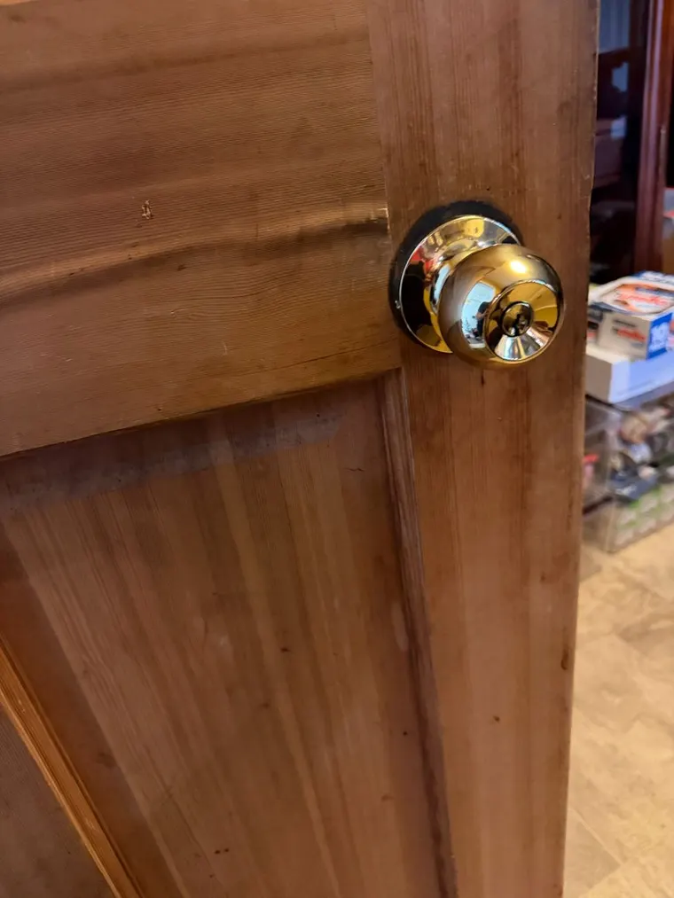 A polished brass knob set fitted to a wooden door