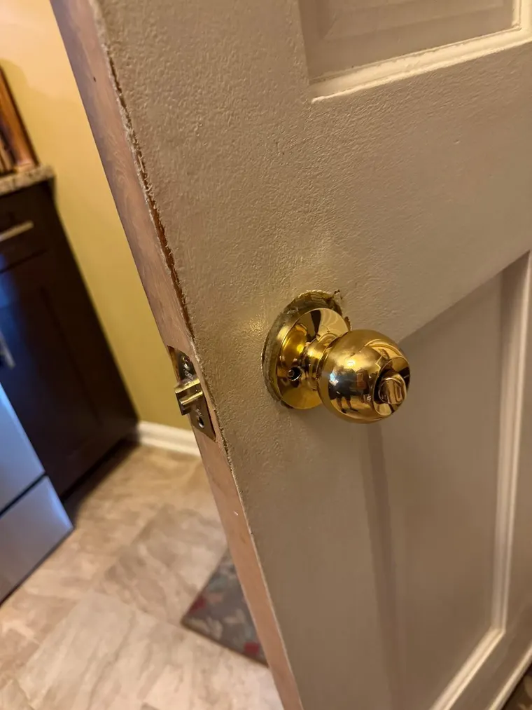 A replaced interior door knob lock seen from a kitchen doorway